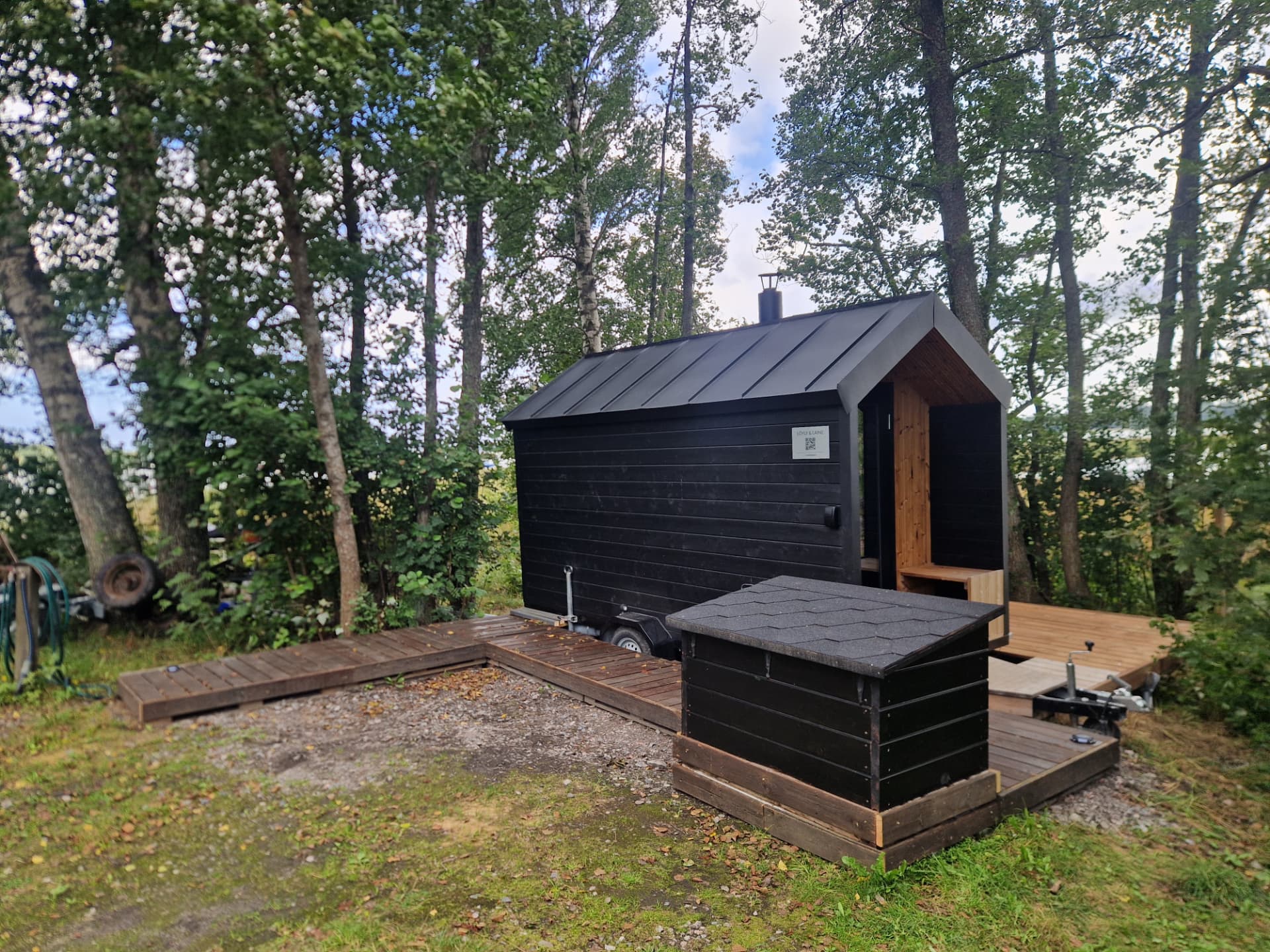 Sauna terassilla puiden keskellä